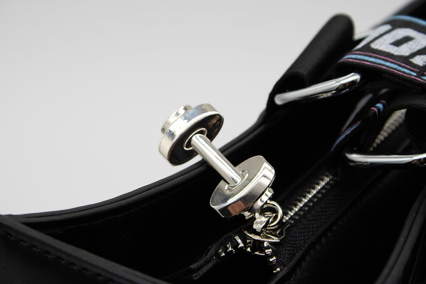 Closeup on Dumbbell Zipper Pull from Graphic Tote Bag with Olivia Newton-John Illustration and Physical Let Me Hear Your Body Talk Lyrics