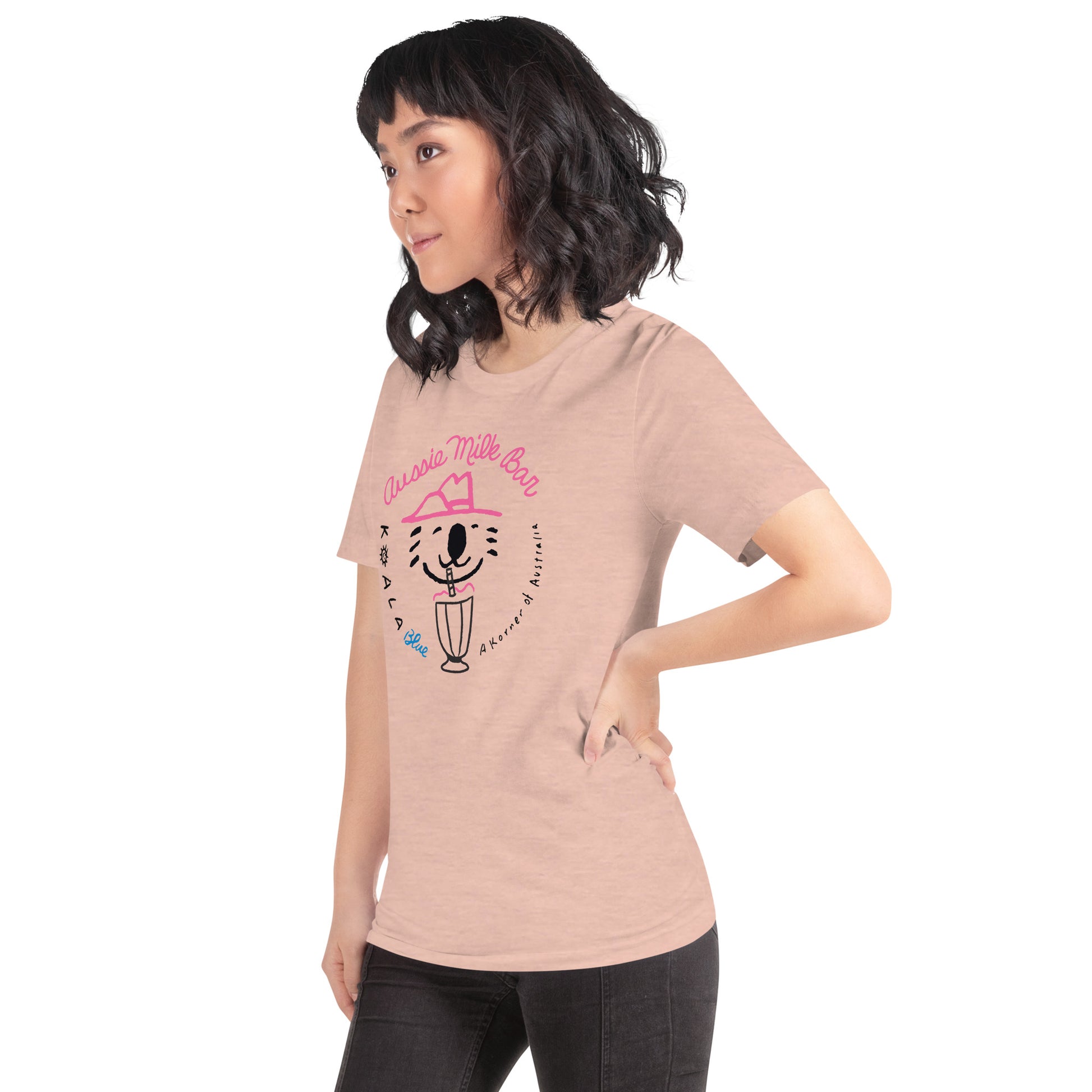 Side View of Woman Wearing Peach-Colored Graphic T-Shirt with Koala Blue Aussie Milk Bar Logo Inspired by Olivia Newton-John’s 1980’s Clothing Brand