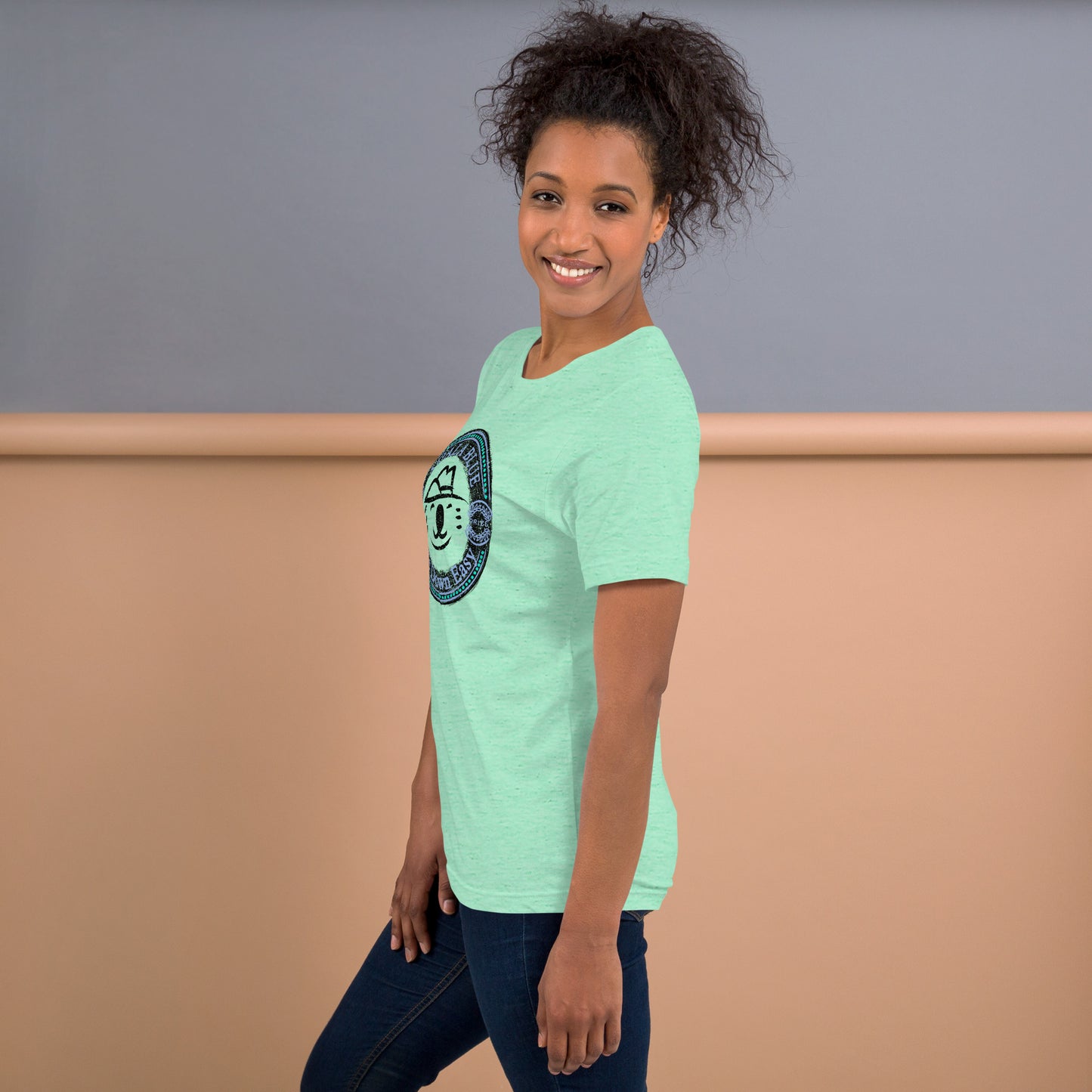 Side View of Woman Wearing Mint-Colored Graphic T-Shirt with Koala Blue Life Down Easy Logo Inspired by Olivia Newton-John’s 1980’s Clothing Brand