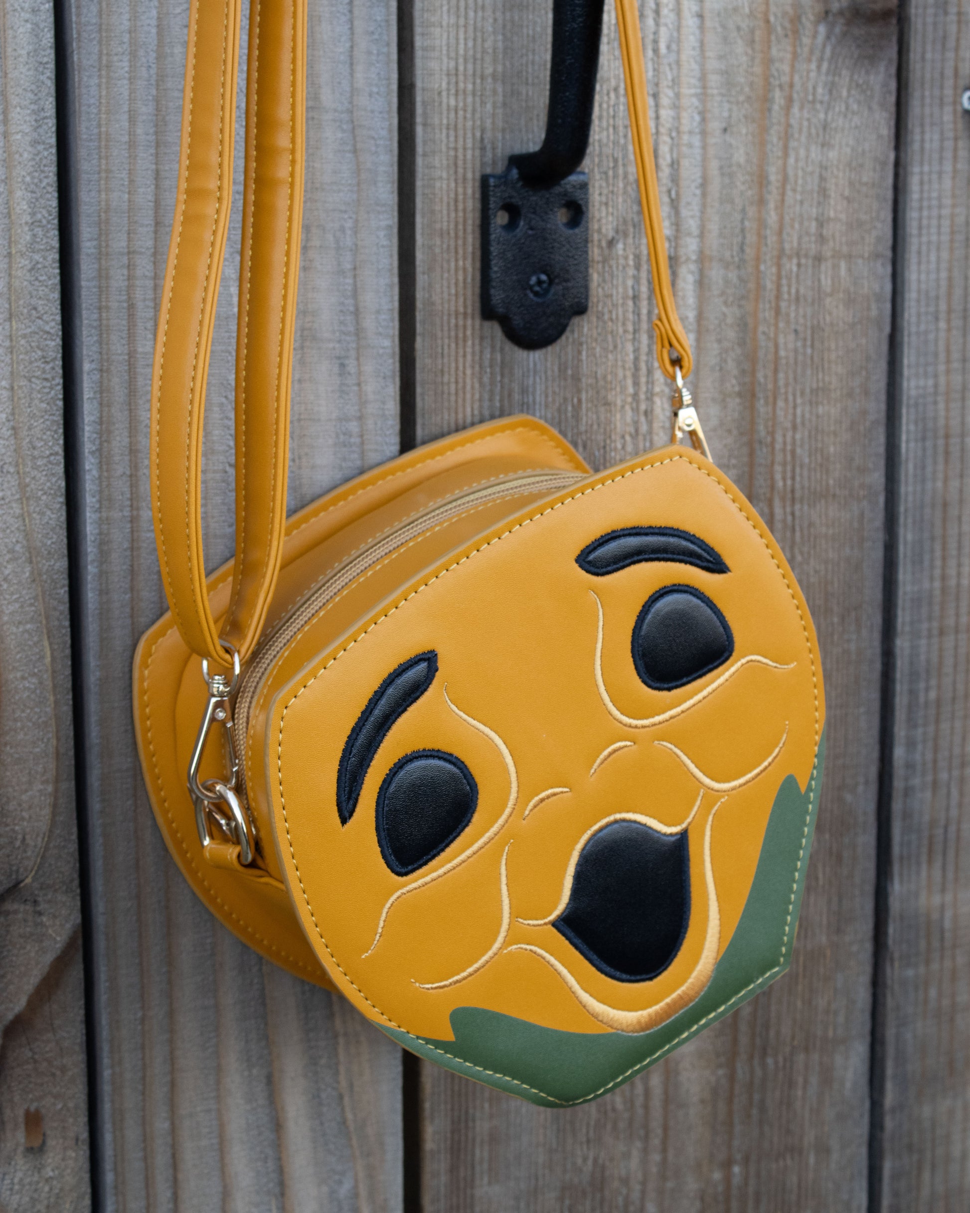 Novelty Purse in the Shape of a Pumpkin Inspired by Disney's Carousel of Progress hanging on wooden gate