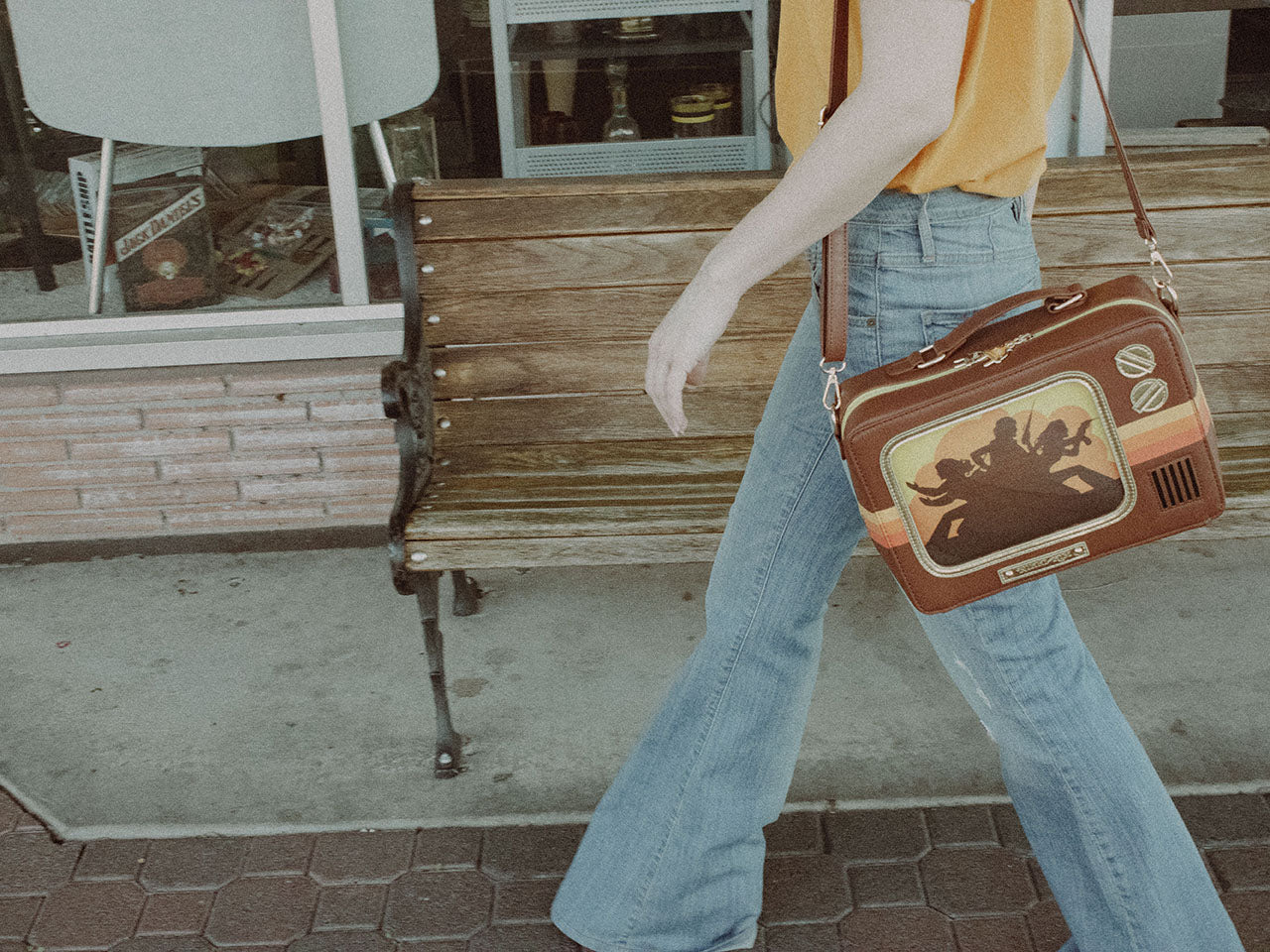 Woman Walking with Retro TV Purse Inspired by Wood Paneled 1970's Television Consoles with Color Stripes and Interchangeable Screens