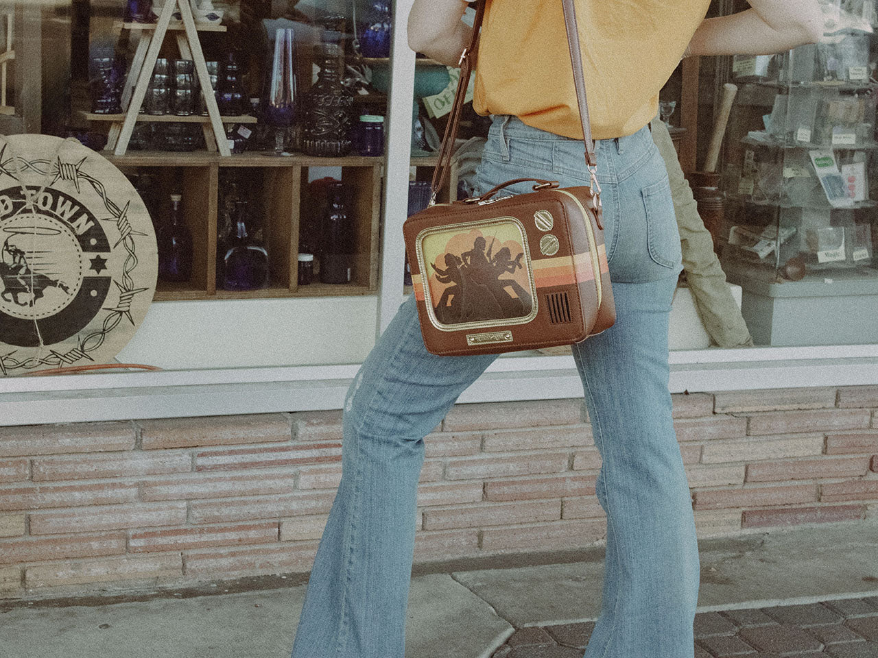 Woman Wearing Retro TV Purse Inspired by Wood Paneled 1970's Television Consoles with Color Stripes and Interchangeable Screens