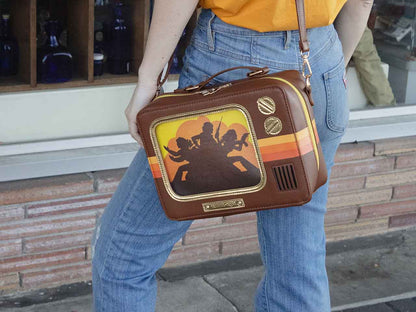 Woman Standing Wearing Retro TV Purse Inspired by Wood Paneled 1970's Television Consoles with Color Stripes and Interchangeable Screens