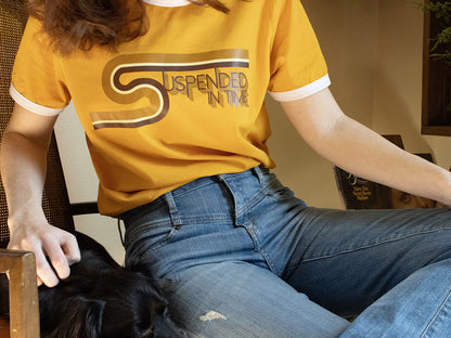 Woman Sitting Wearing Graphic 1970’s Style Ringer T-Shirt with Suspended In Time Song Lyrics from Xanadu Movie