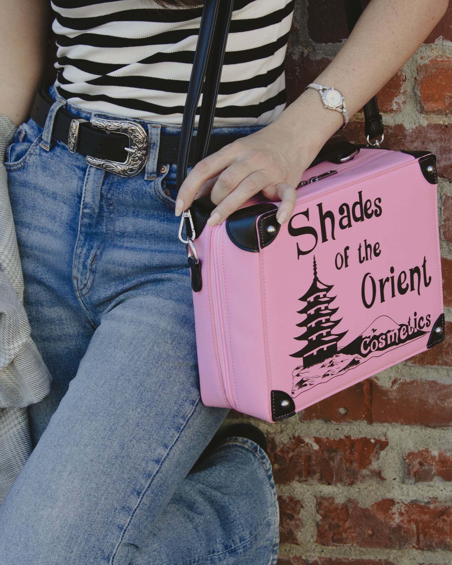 Woman Wearing Prop Replica Purse of TV Series The Nanny Pink Shades of the Orient Cosmetics Makeup Case leaning on Brick Wall