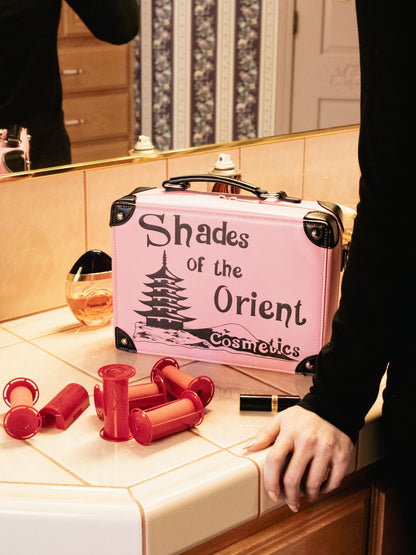 Closeup of Prop Replica Purse of TV Series The Nanny Pink Shades of the Orient Cosmetics Makeup Case on Vanity